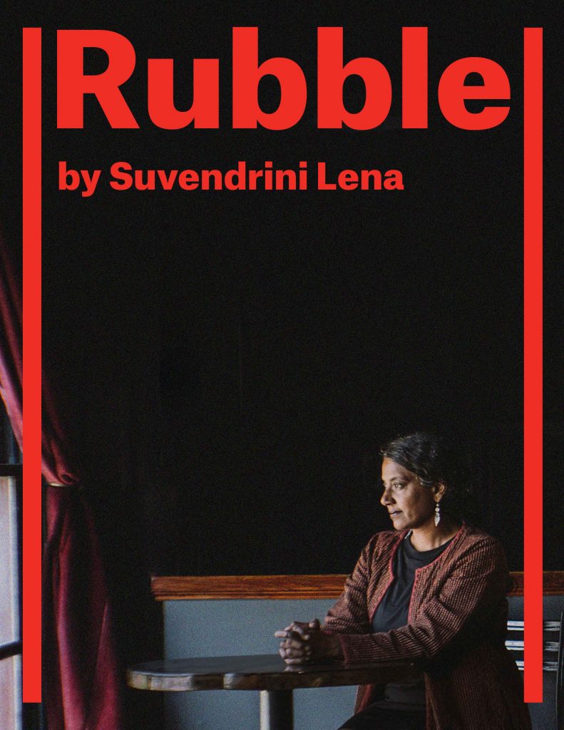 Rubble by Suvendrini Lena. The poster has a large thoughtful negative space that is pitch black. In the foreground Suvendrini sits in a red jacket and black dress, looking out into the window where sunshine comes through