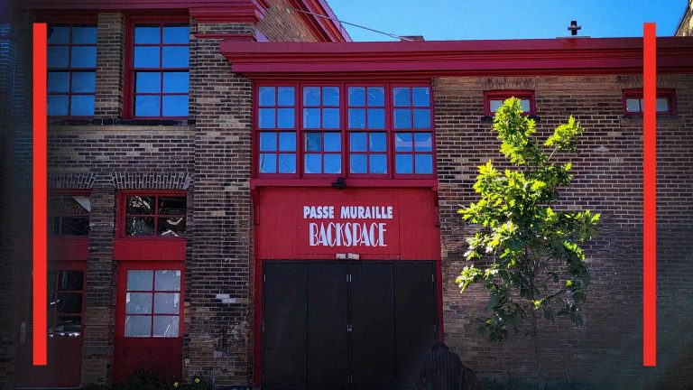 The backspace has a separate entrance from ryerson avenue, with black barn doors with a red sign on top that reads passe muraille backspace
