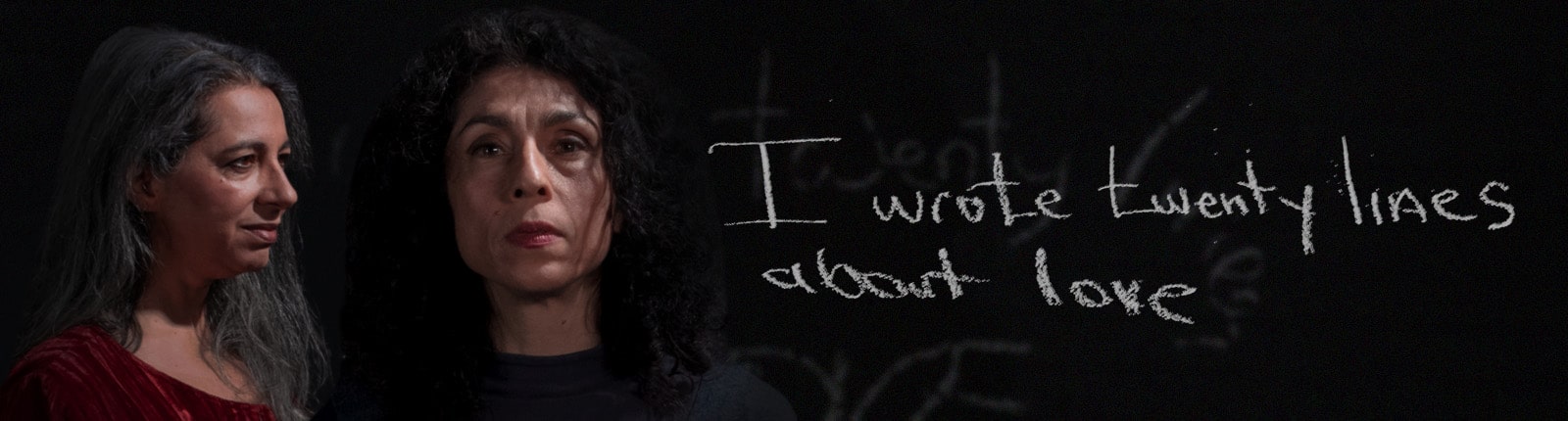 Roula Said, playing the poet, looks sideways with a faint smile wearing a red robe. Lara Arabian, playing Leila, looks ahead with feeling. A white chalk writes "I wrote twenty lines about love"