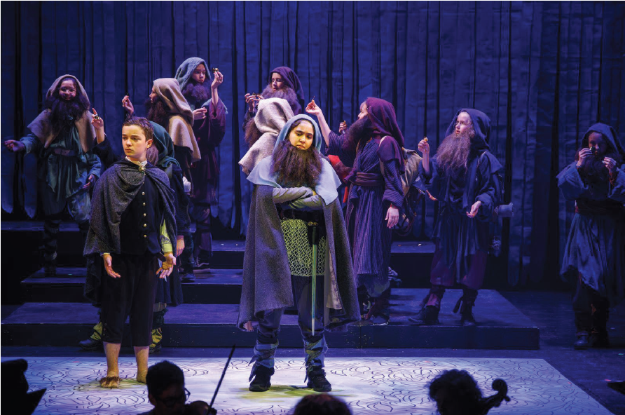 Lilia as a Dwarf in front of many other cast in the background.